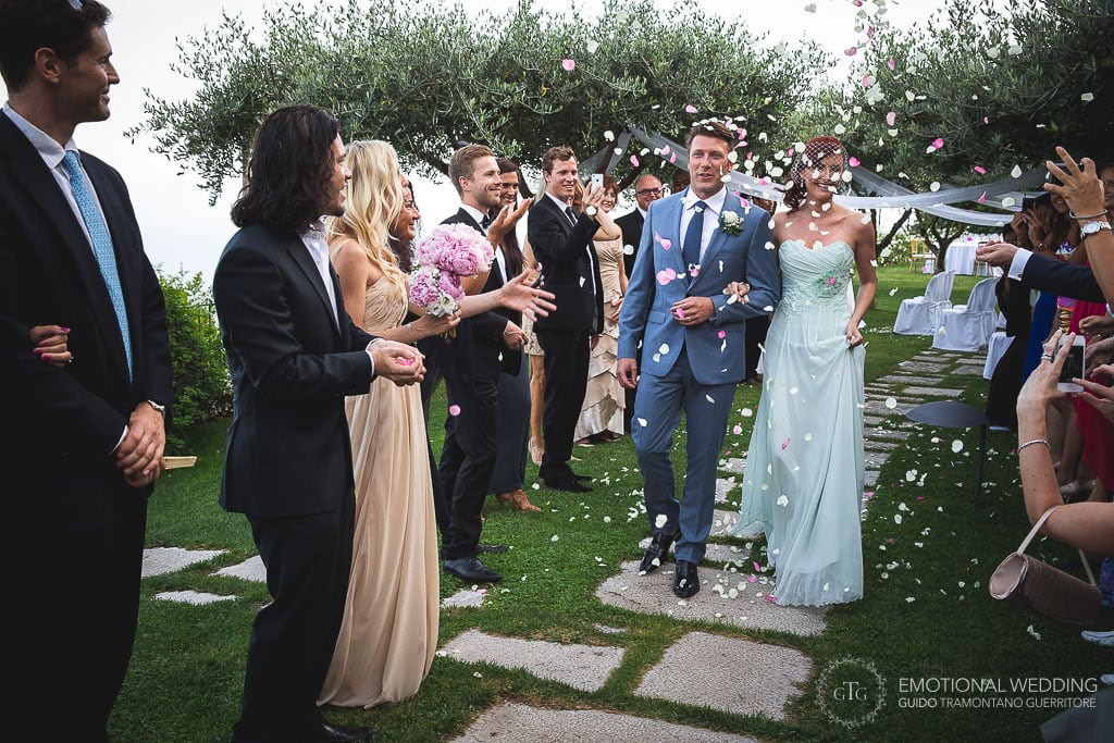 ospiti lanciano i fiori agli sposi al termine della cerimonia di un matrimonio sudafricano in italia