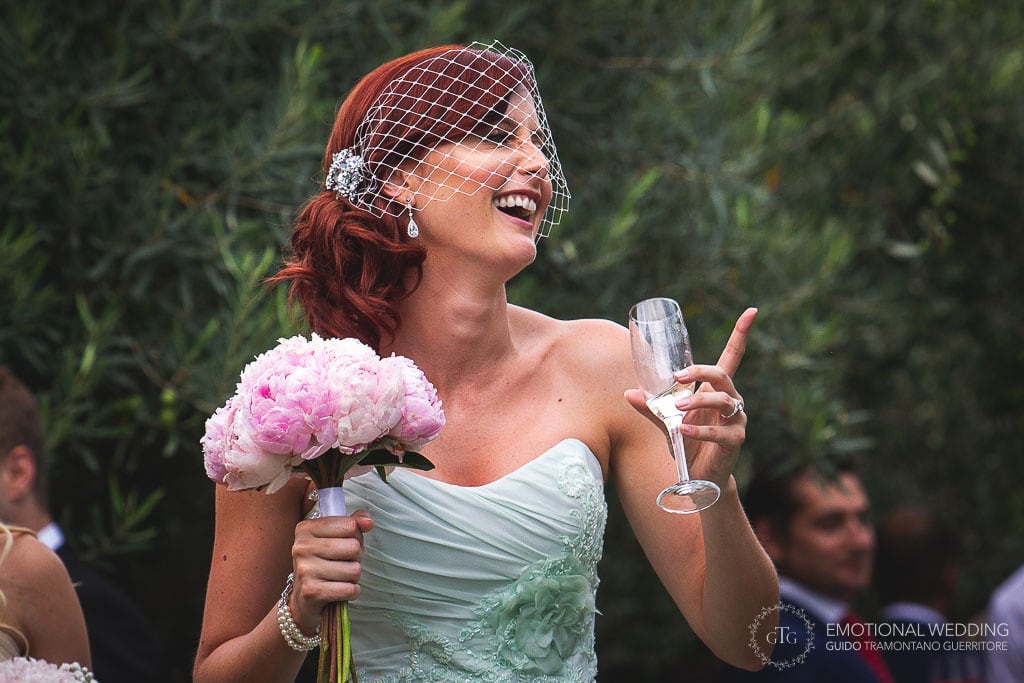 bride laughs holding a drink in her hand at hotel caruso in ravello