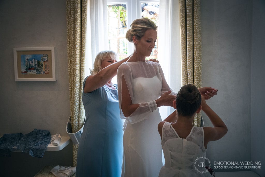 mother of the bride helps her daughter getting ready