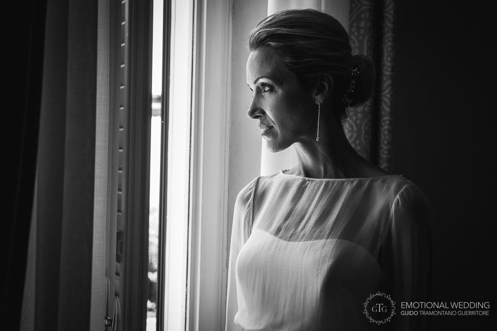bride looking out of the window after getting ready for her wedding in maiori