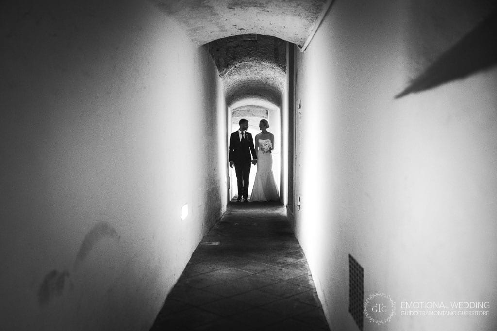 bride and groom walking through a narrow alley in maiori