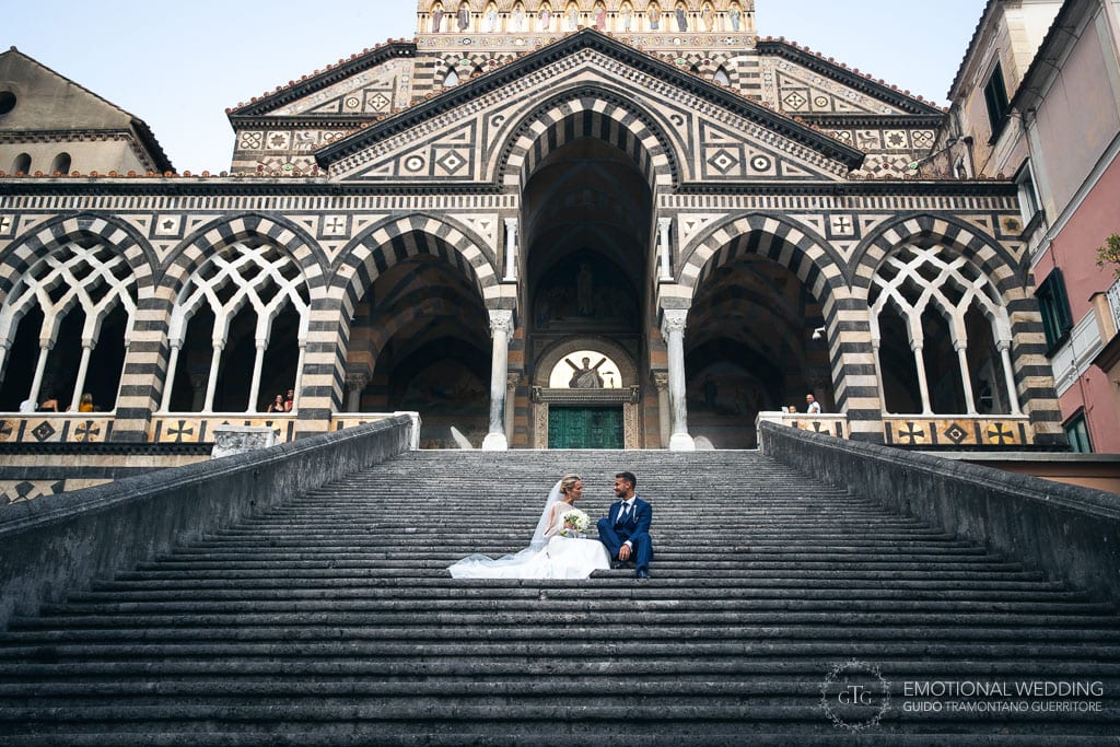 duomo di Amalfi e sposi seduti sulle scale a un matrimonio a Maiori