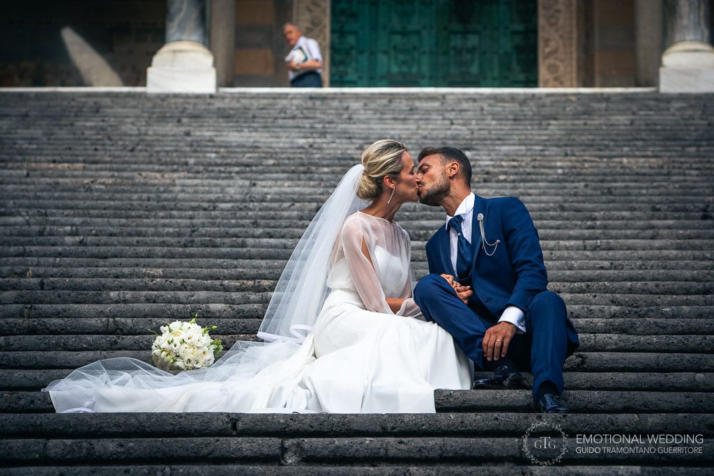 bride and groom kiss sitting on the stairs of the Amalfi cathedral