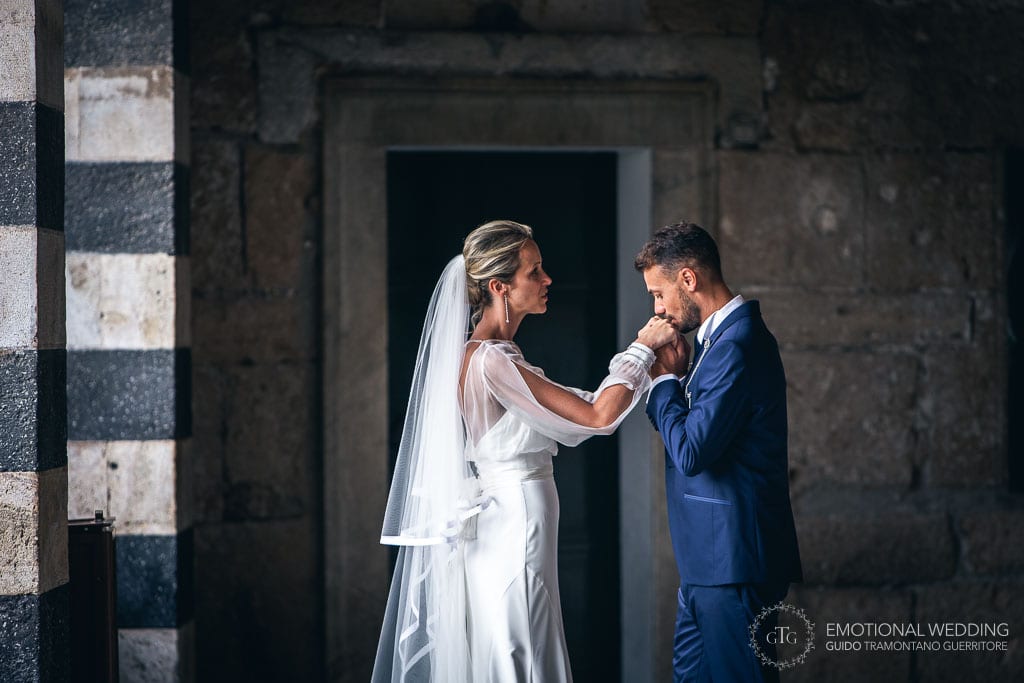 groom kissing the bride's hands at the Amalfi cathedral