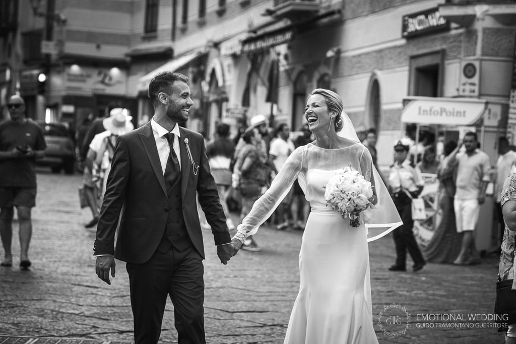 bride and groom smiling and walking in the town in Amalfi