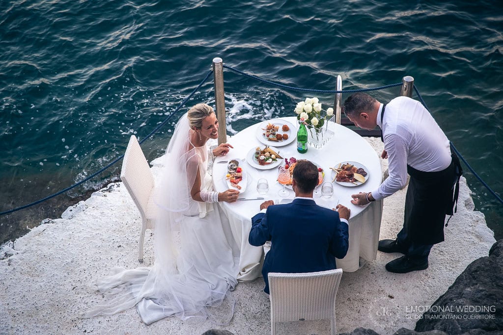 bride and groom having their wedding dinner by the water at Torre Normanna in maiori