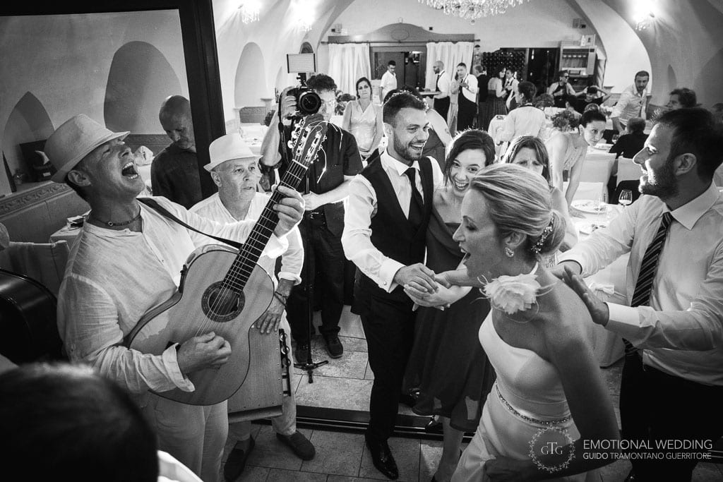 bride and groom dancing on the beat of folk musicians at their wedding in maiori