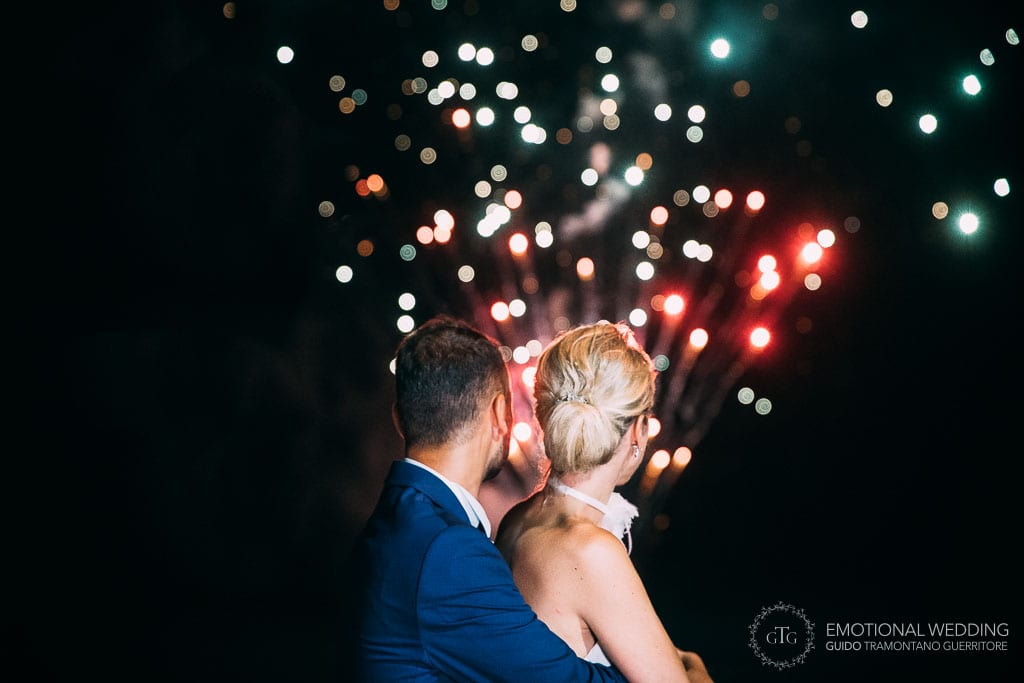 bride and groom with fireworks in the background at their wedding in maiori Amalfi coast