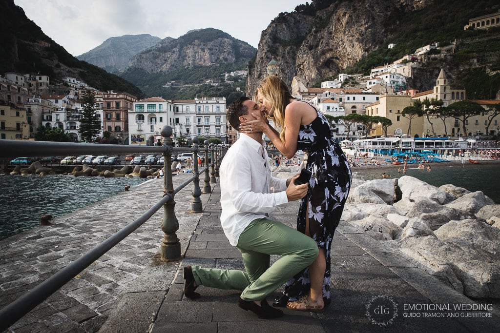 a man makes a surprise marriage proposal on the amalfi pier