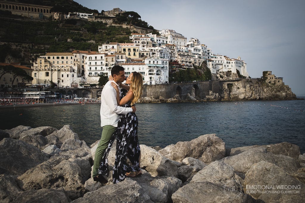 coppia di fidanzati sugli scogli al molo di Amalfi per una proposta di matrimonio