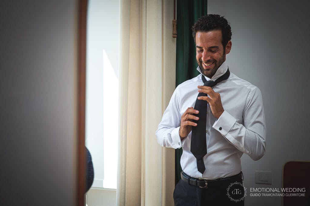groom smiling while wearing the tie for his wedding in ravello