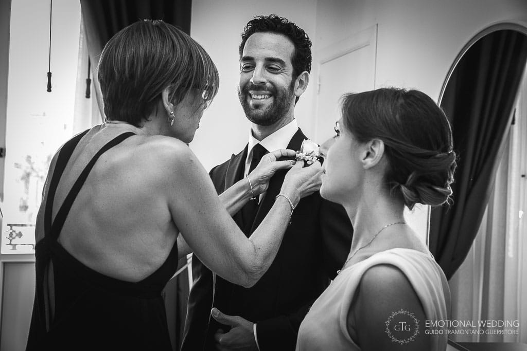 mother of the groom helps with boutonniere