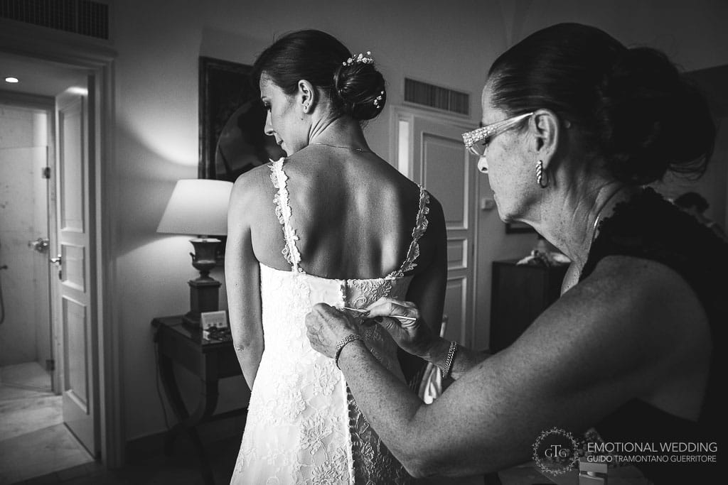 mother of the bride buttons up the wedding dress