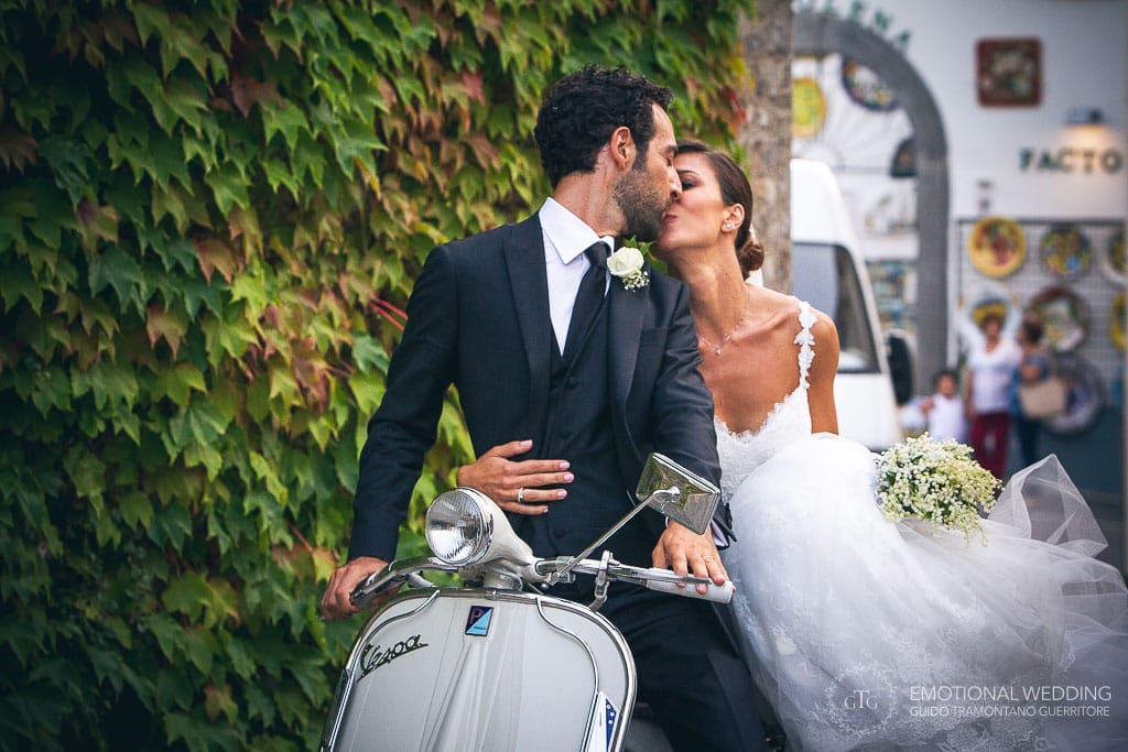 wedding couple kissing on vintage scooter