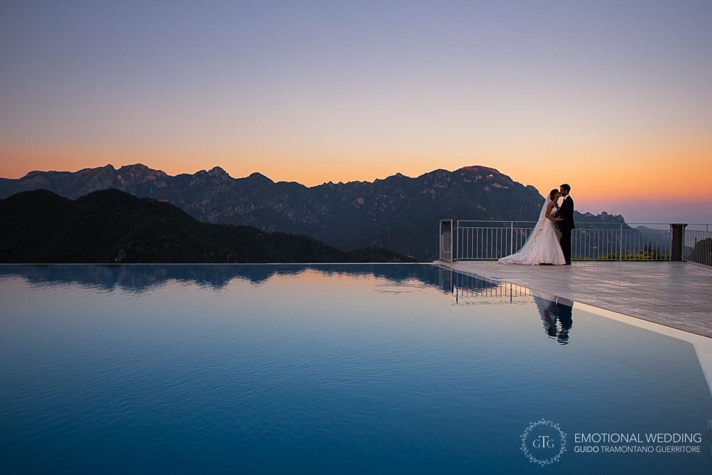 sposi riflessi nella piscina al tramonto ad un matrimonio al belmond hotel Caruso di ravello