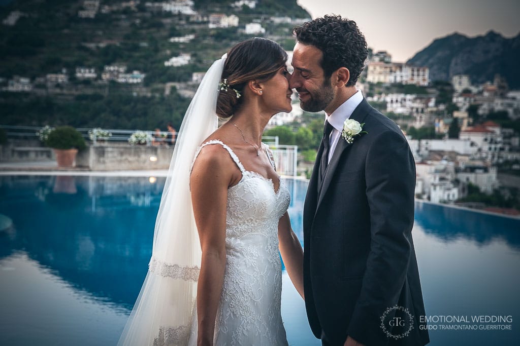 wedding couple kissing by infinity pool at hotel caruso in ravello