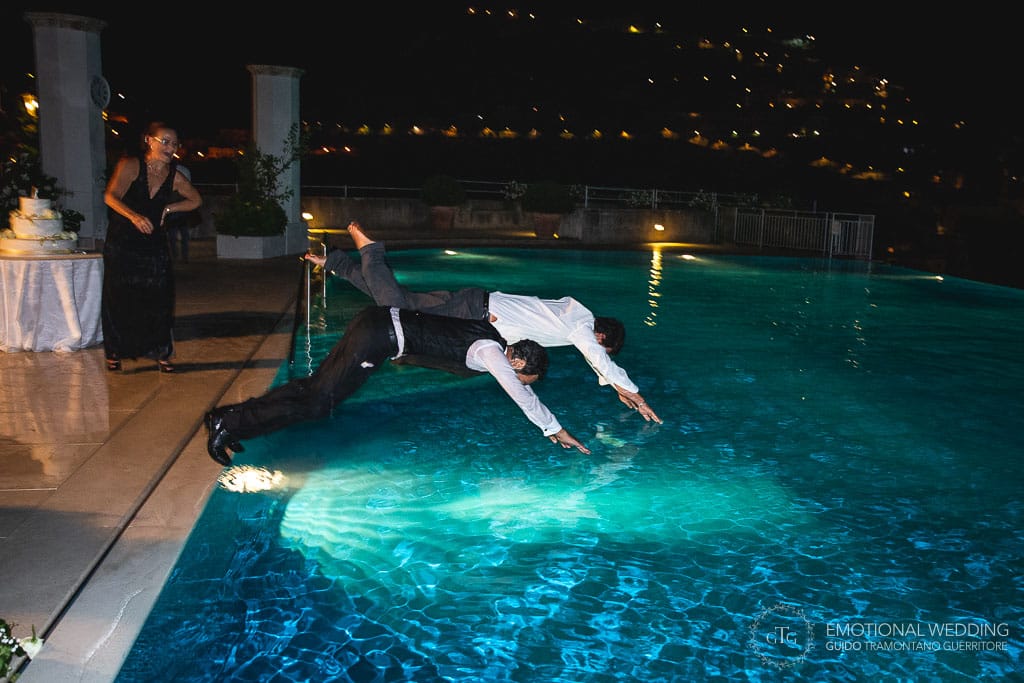 the groom and a guest jumping into the swimming pool