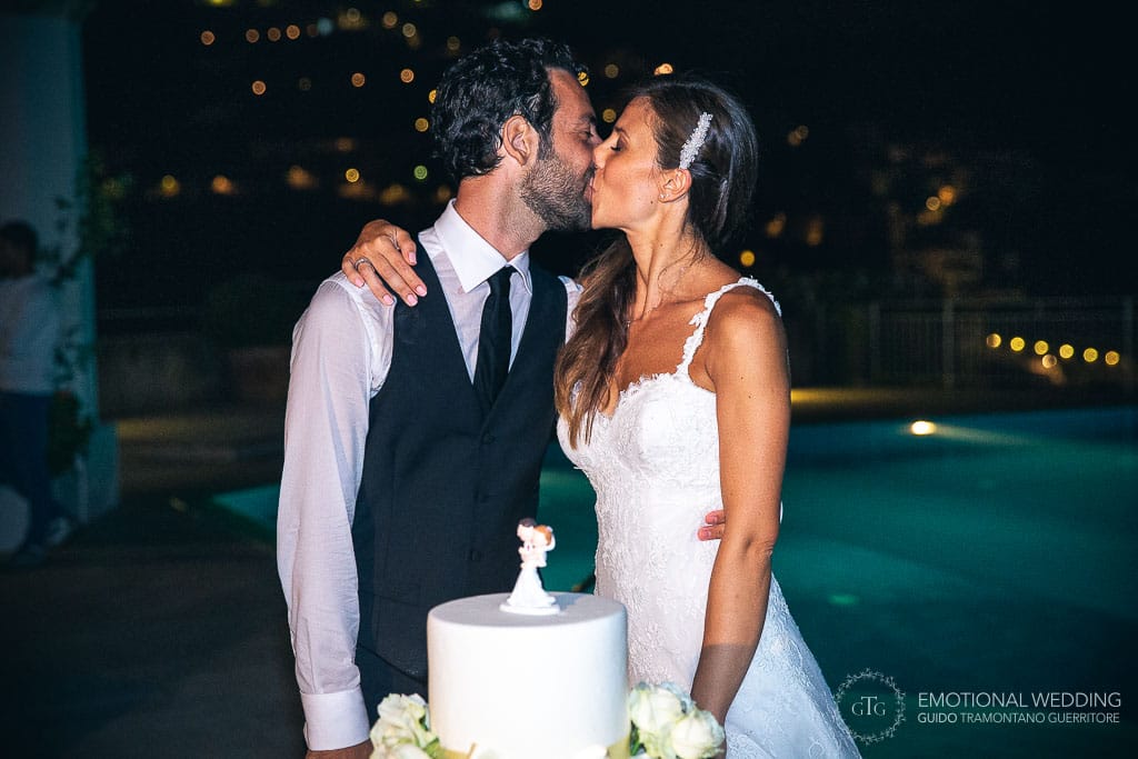 wedding couple kiss at cake cutting at hotel Caruso in ravello