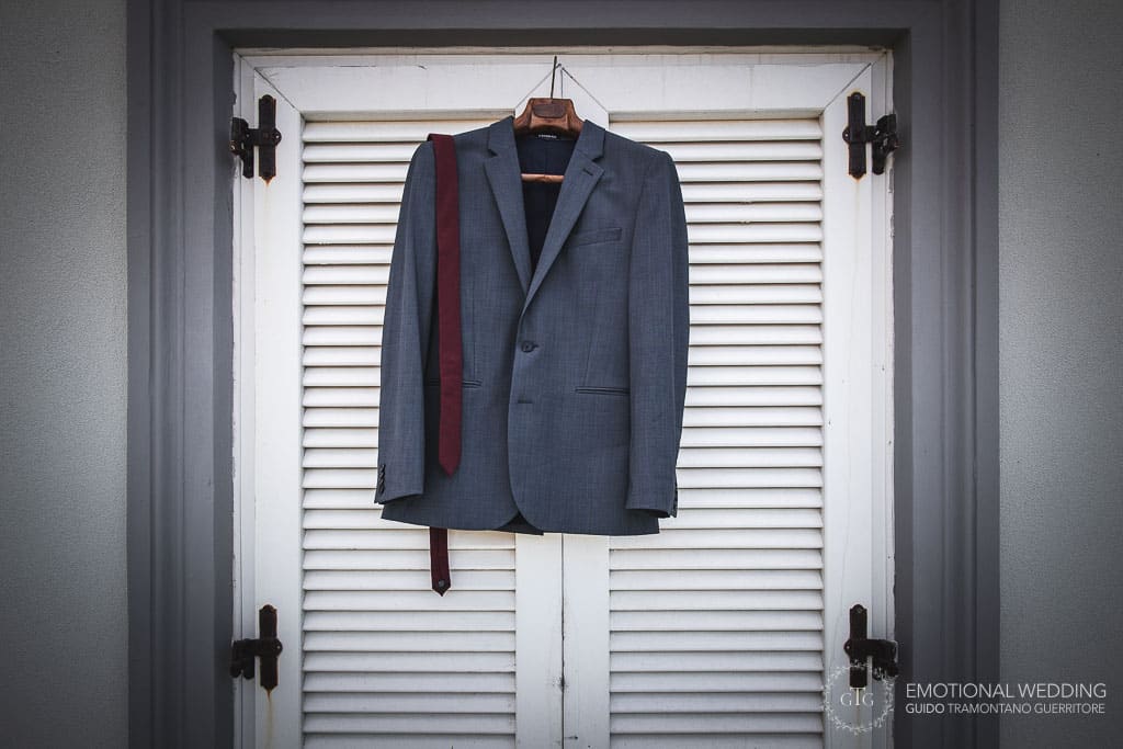 groom's jacket hanged on the window of his room at a wedding in sorrento