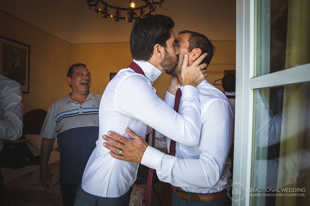 groom kisses best man while getting ready at a wedding in sorrento