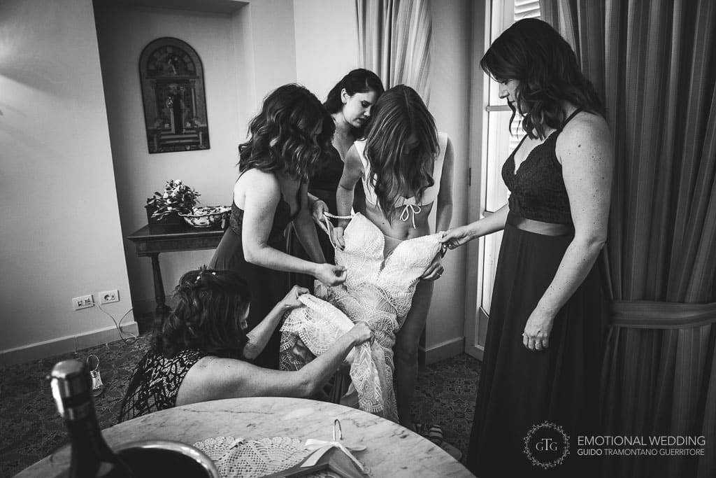 bridesmaids and mother helping the bride getting ready at a wedding in sorrento