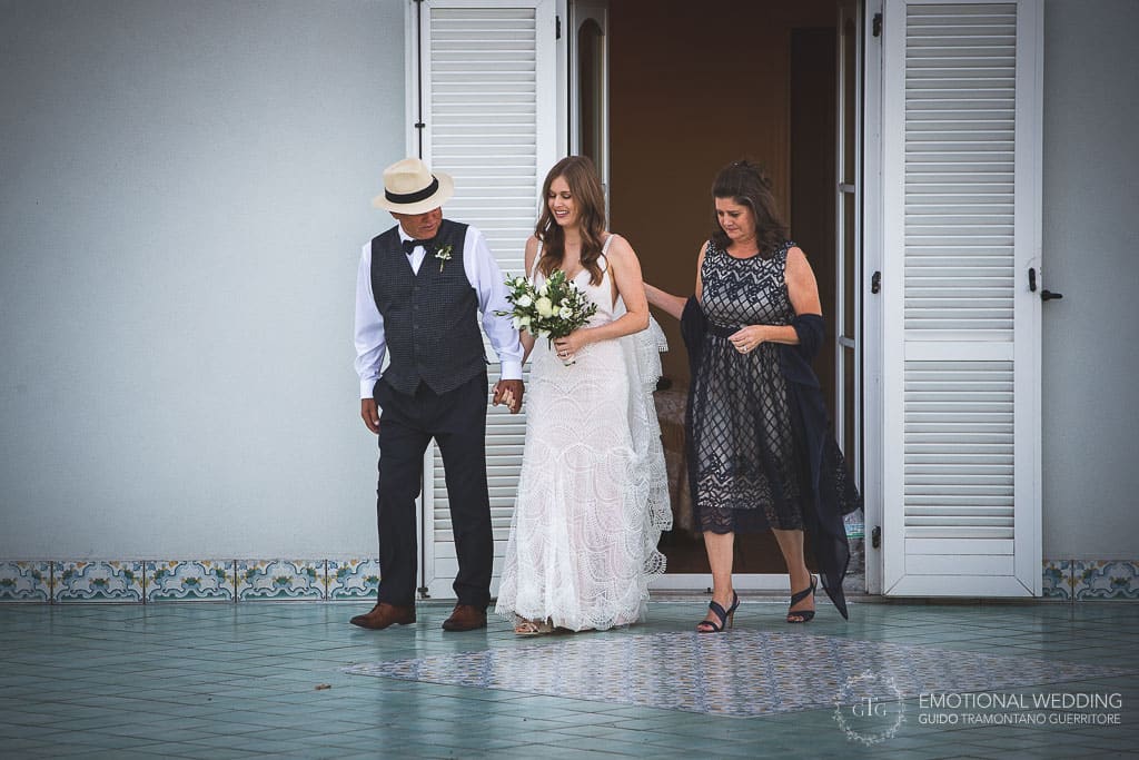 bride and her parents exiting hotel room at a wedding in sorrento