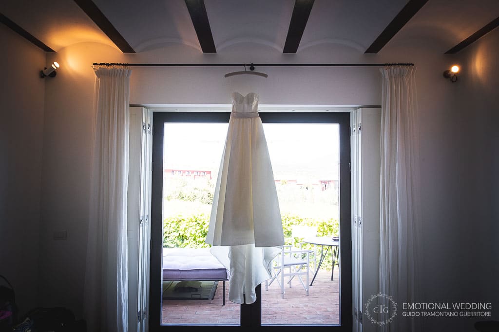 wedding dress hanged at the window at Locanda Rossa in tuscany