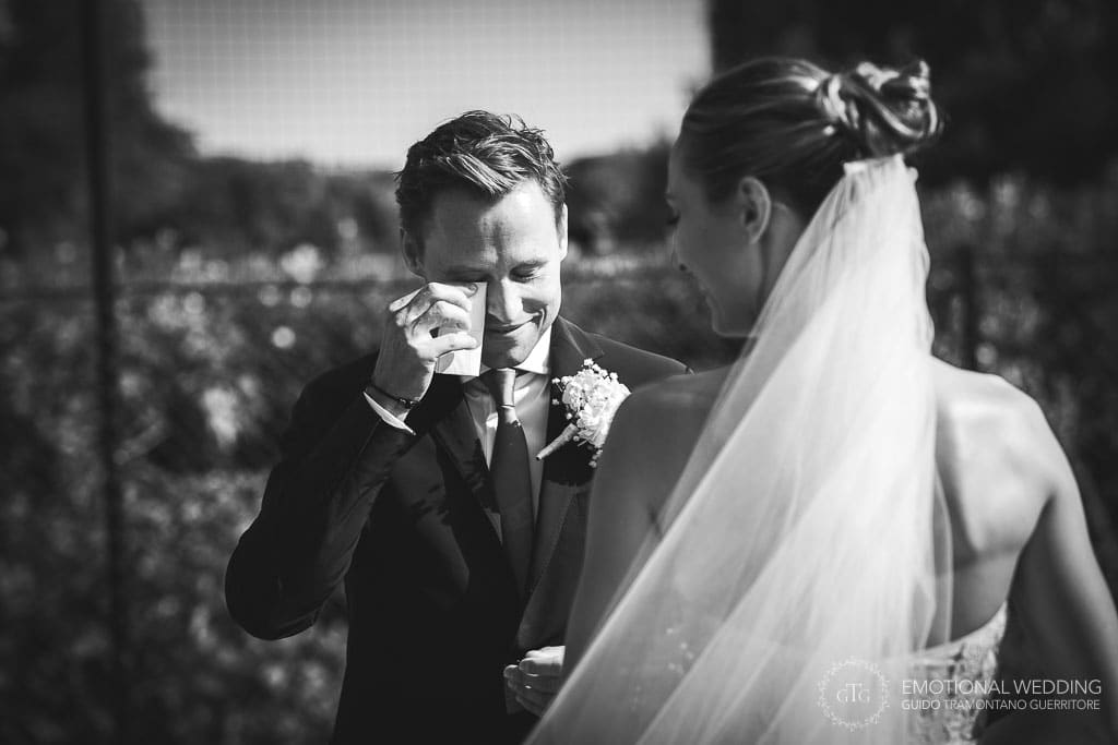 groom wipes tears during wedding ceremony in tuscany