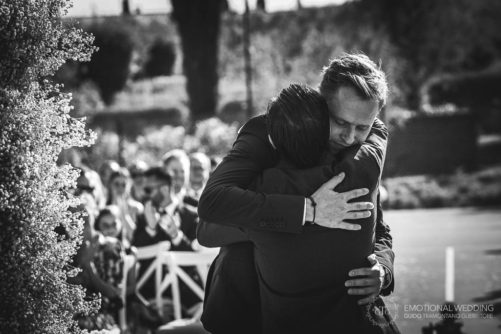 sposo e testimone si abbracciano durante la cerimonia di un matrimonio in toscana