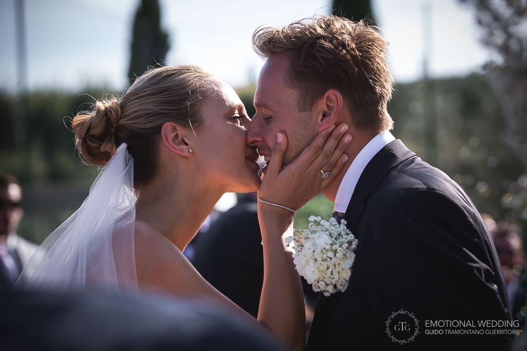 first kiss of wedding couple after ceremony in tuscany
