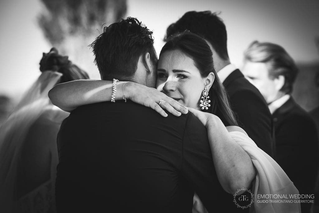 amica dello sposo in lacrime lo abbraccia dopo la cerimonia di un matrimonio in toscana