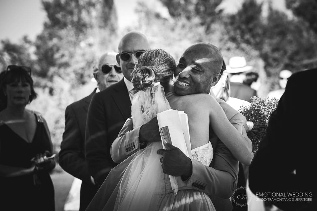guest hugs the bride at wedding ceremony in tuscany
