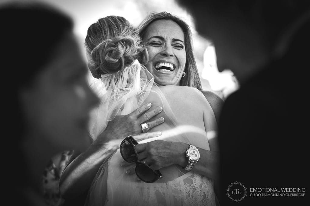 friend hugs the bride after wedding ceremony in tuscany