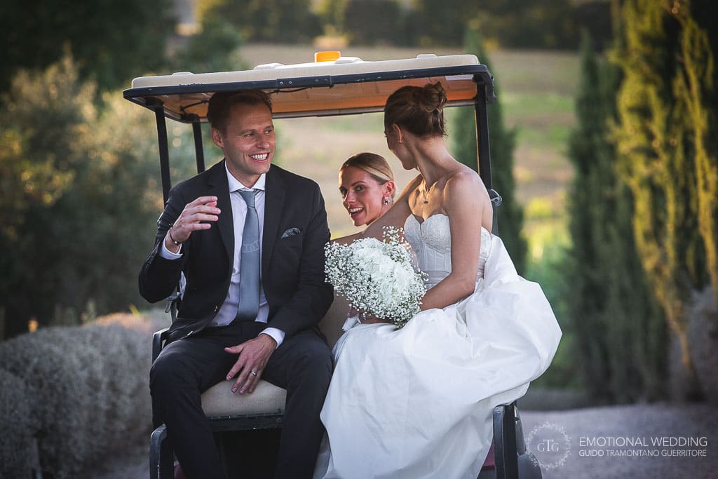 bride and groom riding a golf cart in the tuscany countryside