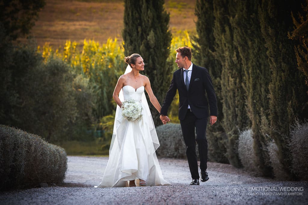 wedding couple walking in the tuscan countryside at golden hour