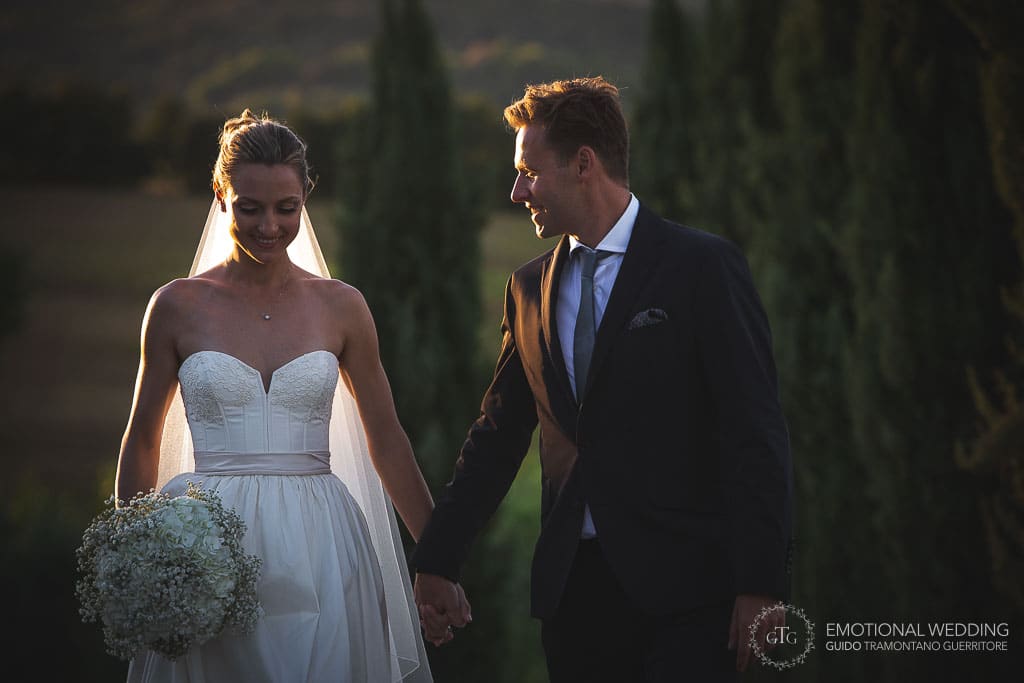 low key portrait of wedding couple walking in the tuscany countryside