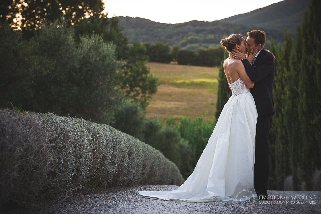 bride and groom kissing in tuscany countryside