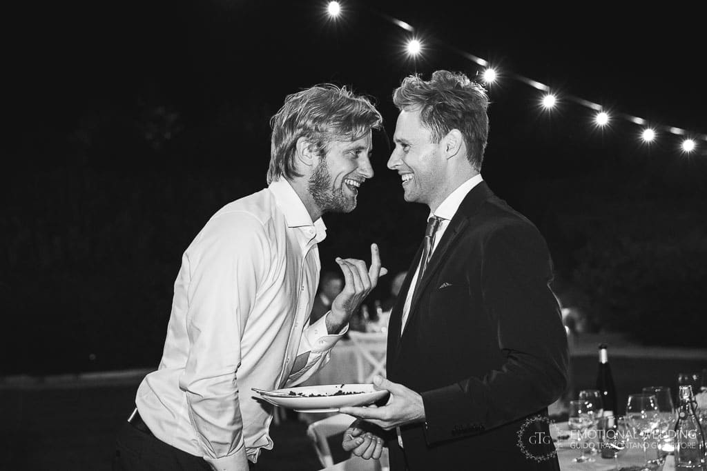 groom and a friend laughing at a wedding reception in tuscany