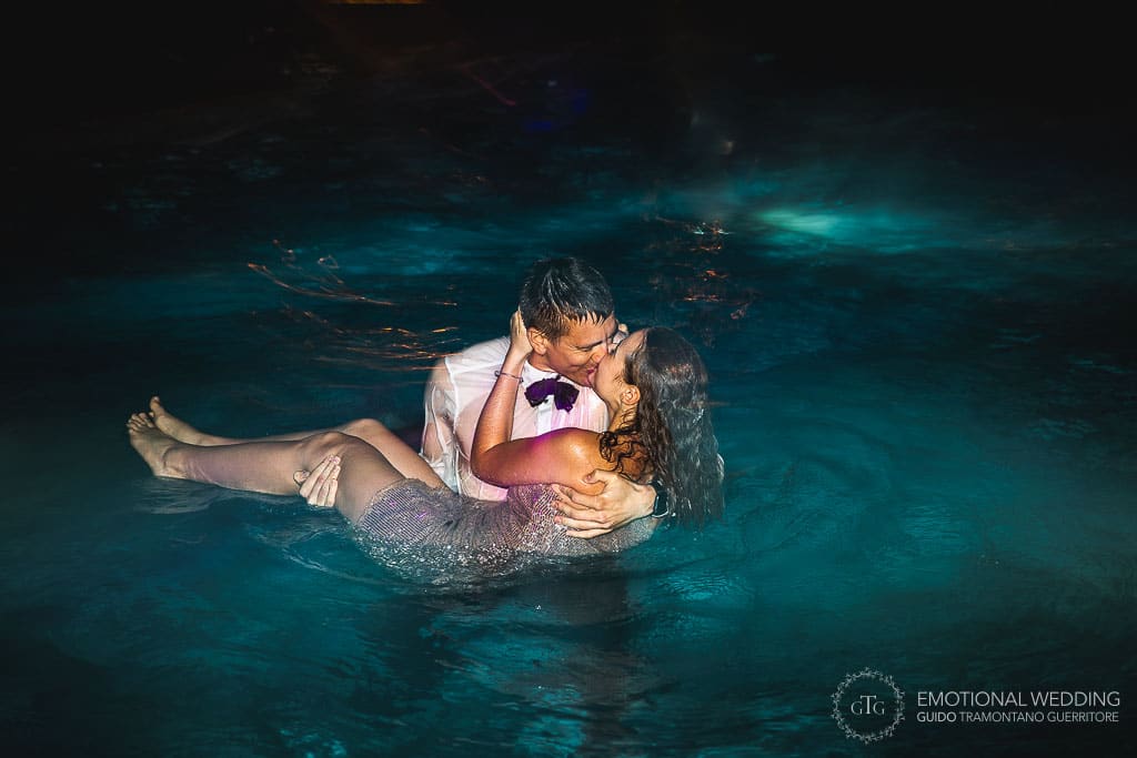 couple kissing in the swimming pool at a wedding party in tuscany