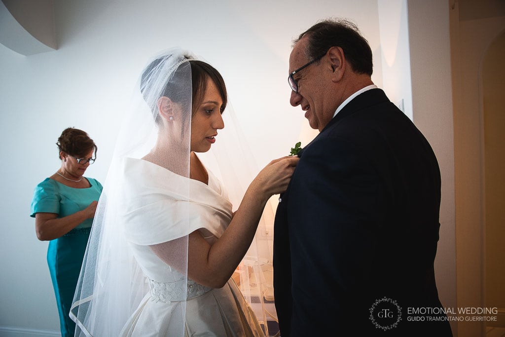 bride helps her father with the boutonniere at a wedding in praiano