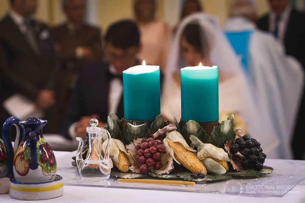 candele sull'altare e sposi sullo sfondo a un matrimonio nella chiesa di san Gennaro a praianoa