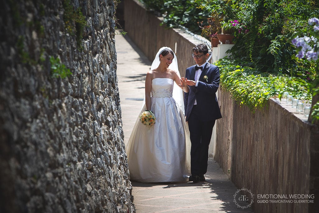 sposi guardano le loro fedi passeggiando al loro matrimonio a Praiano