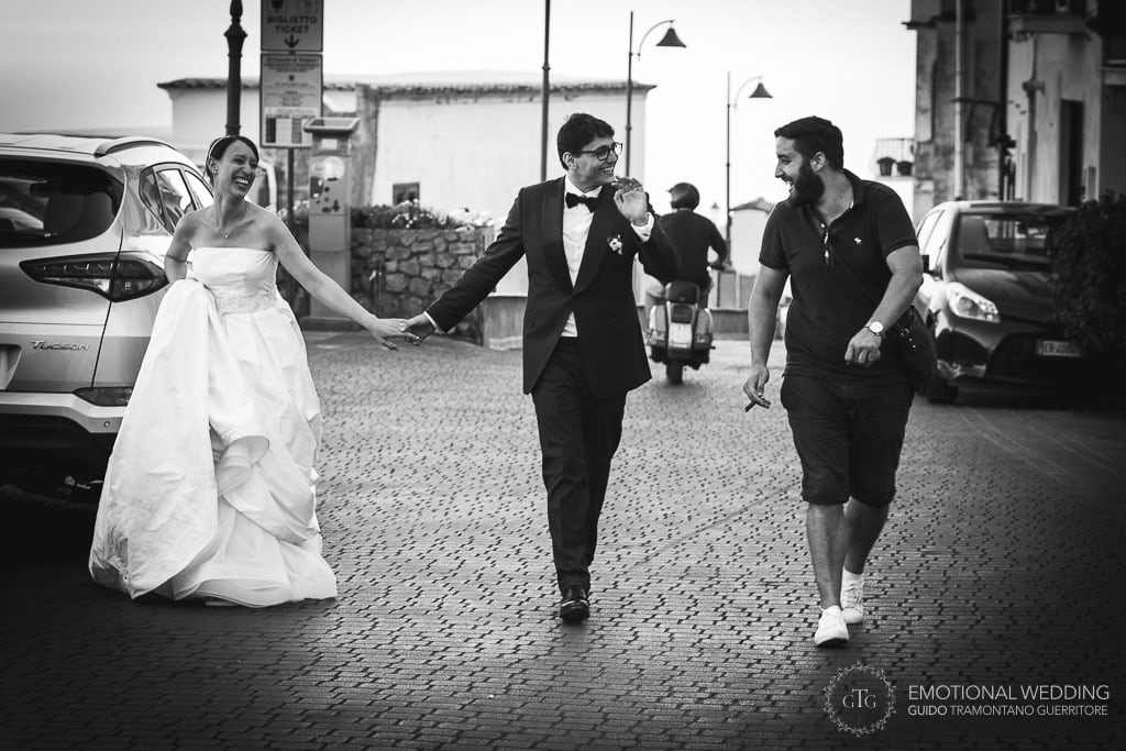 candid shot of a wedding couple meeting a guy on the street in Praiano