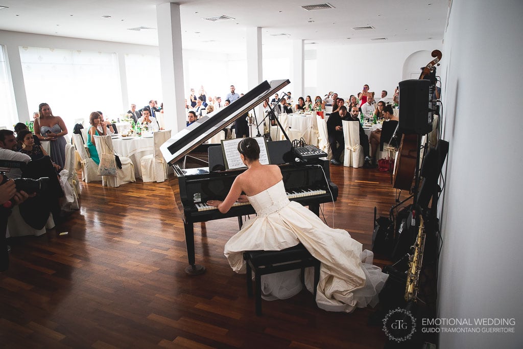 sposa suona il pianoforte al ricevimento del suo matrimonio a Praiano