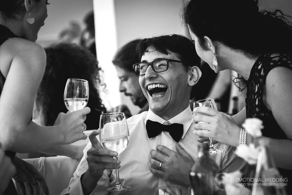 candid shot of the groom laughing at wedding party in Praiano