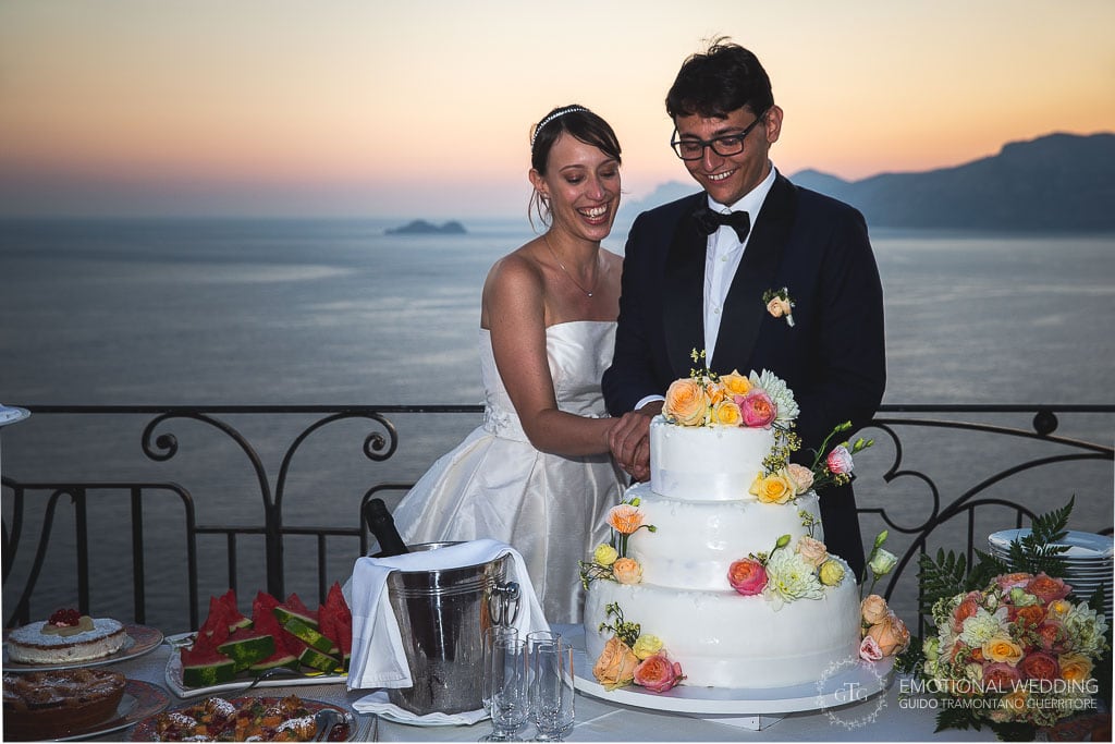 wedding couple cutting the cake at hotel tramonto d'oro in Praiano