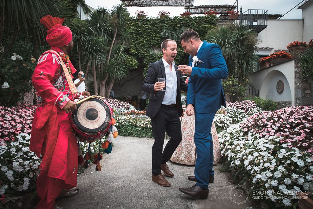 groom and best man dancing to the beat of a DHOL player in the garden of hotel Parsifal in ravello