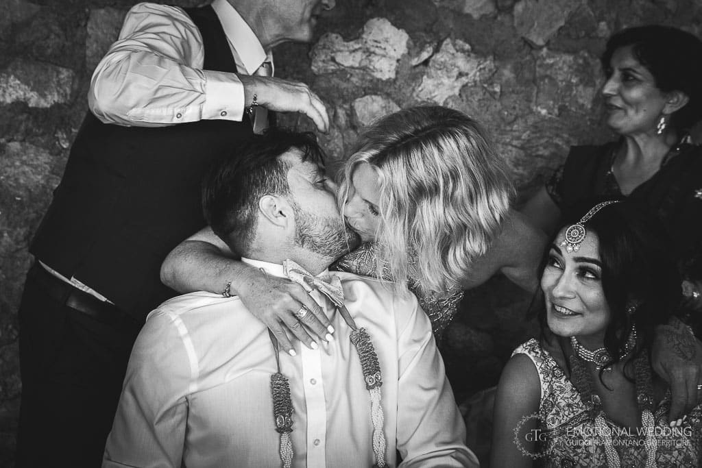 sister kissing groom at a wedding party in ravello