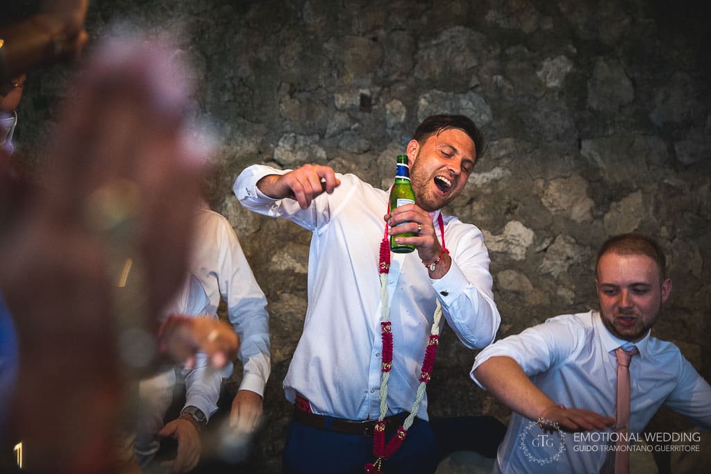 groom dances holding a beer bottle at a wedding in ravello