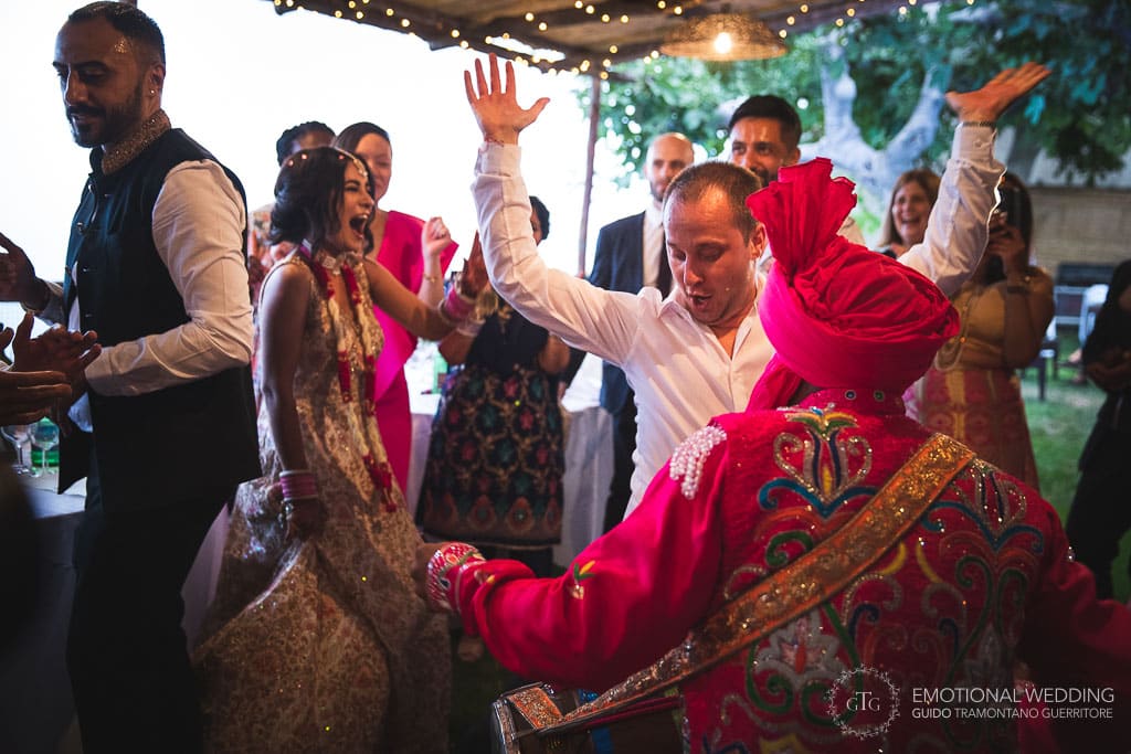 best man dancing to the beat of dhol at an indian wedding party in ravello